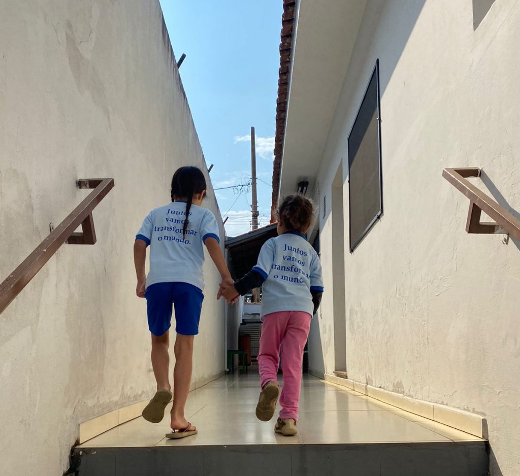 Crianças de mãos dadas subindo uma rampa